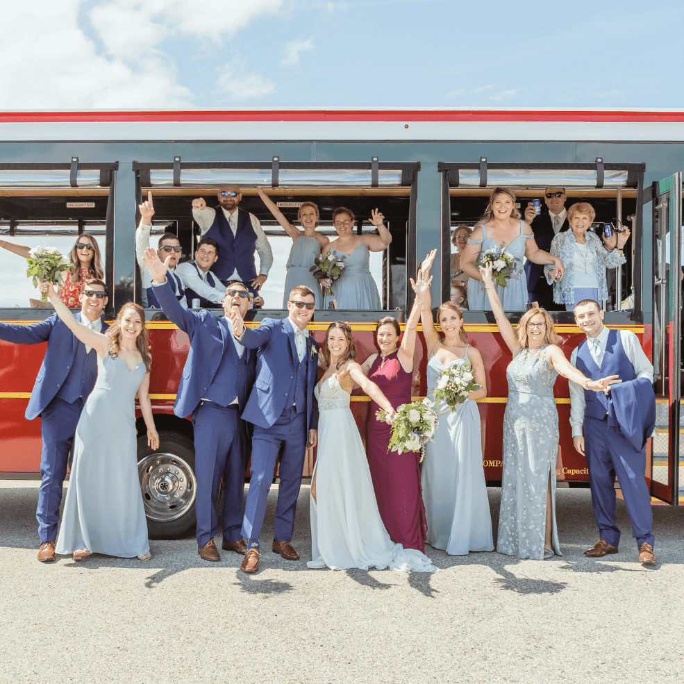 Wedding party posing in front of a vintage trolley at Union Bluff Hotel