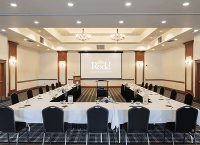 Spacious conference room with U-shaped tables, projector screen, and seating at Rodd Crowbush Golf & Beach Resort