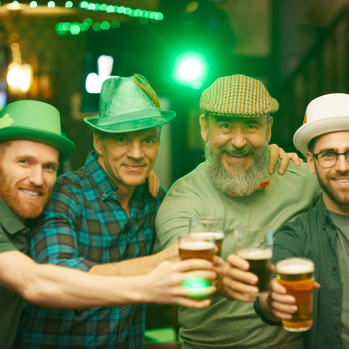 4 gentlemen in green attire and hats celebrating St. Patrick's day with beers