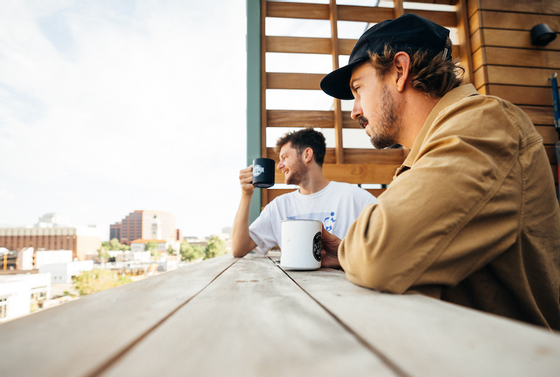 Two people having coffee by the balcony at Kinship Landing