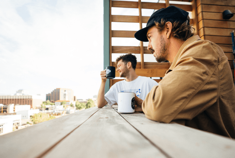 Two people having coffee by the balcony at Kinship Landing