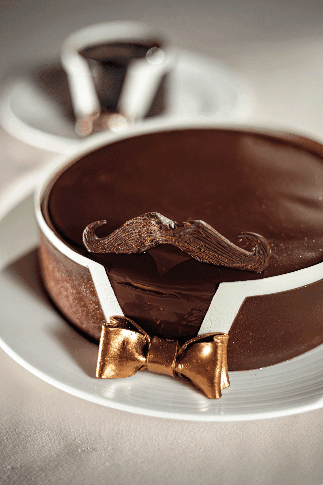 Gourmet Father\'s Day chocolate cake styled like a tuxedo with a mustache and gold bow tie at Hotel Okura Manila