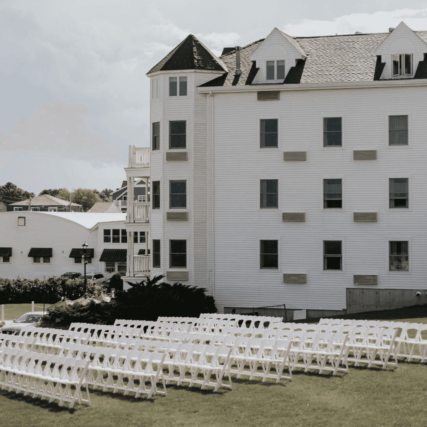 Rows of white folding chairs set up on a grassy area for an outdoor wedding at Union Bluff Hotel