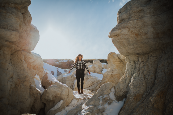 A girl posing among boulders of rocks near Kinship Landing