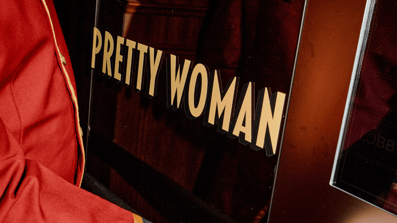 Bellboy holding a ticket for Pretty Woman: The Musical Package.
