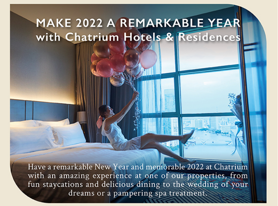 A woman celebrating in a suite at Chatrium Hotels & Residences