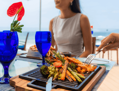 Woman at Sunset Restaurant with grilled vegetables on plate at Buenaventura Grand Hotel and Spa
