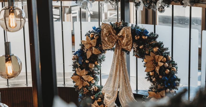 Festive wreaths with gold decorations and blue ribbons hanging by windows overlooking the sea at The View Hotel Eastbourne