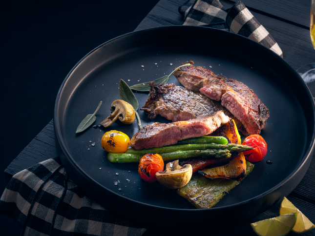 Primer plano de un plato de cordero a la parrilla servido en One Hotels