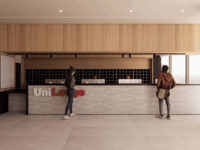 Two people standing in front of a reception desk at UniLodge Brisbane City.