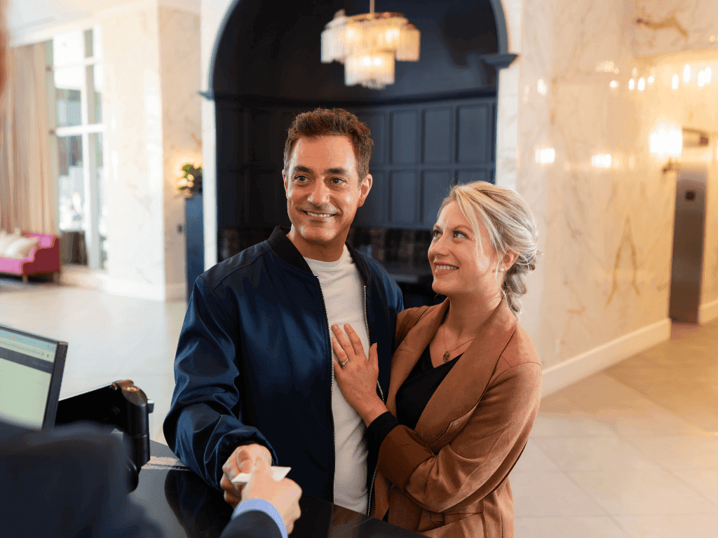 Couple at the reception desk checking in with Weekend Parking Offer at The Sutton Place Hotel Halifax.