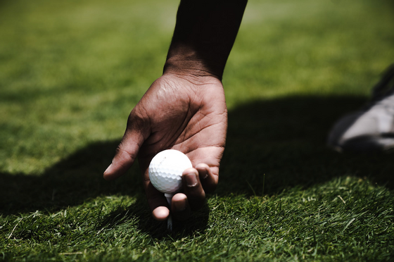 Closeup of a golf ball on a man's hand at Richmond Hill Hotel