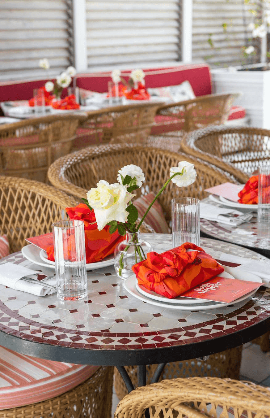 A dining table set with flowers and red napkins