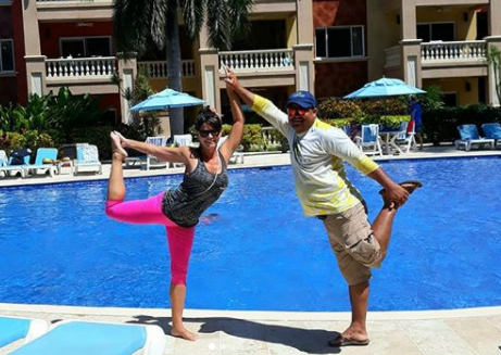 Couple giving a yoga pose by the outdoor pool at Infinity Bay