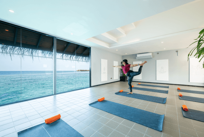 Yoga master practicing yoga in a yoga studio with ocean view at Grand Park Kodhipparu