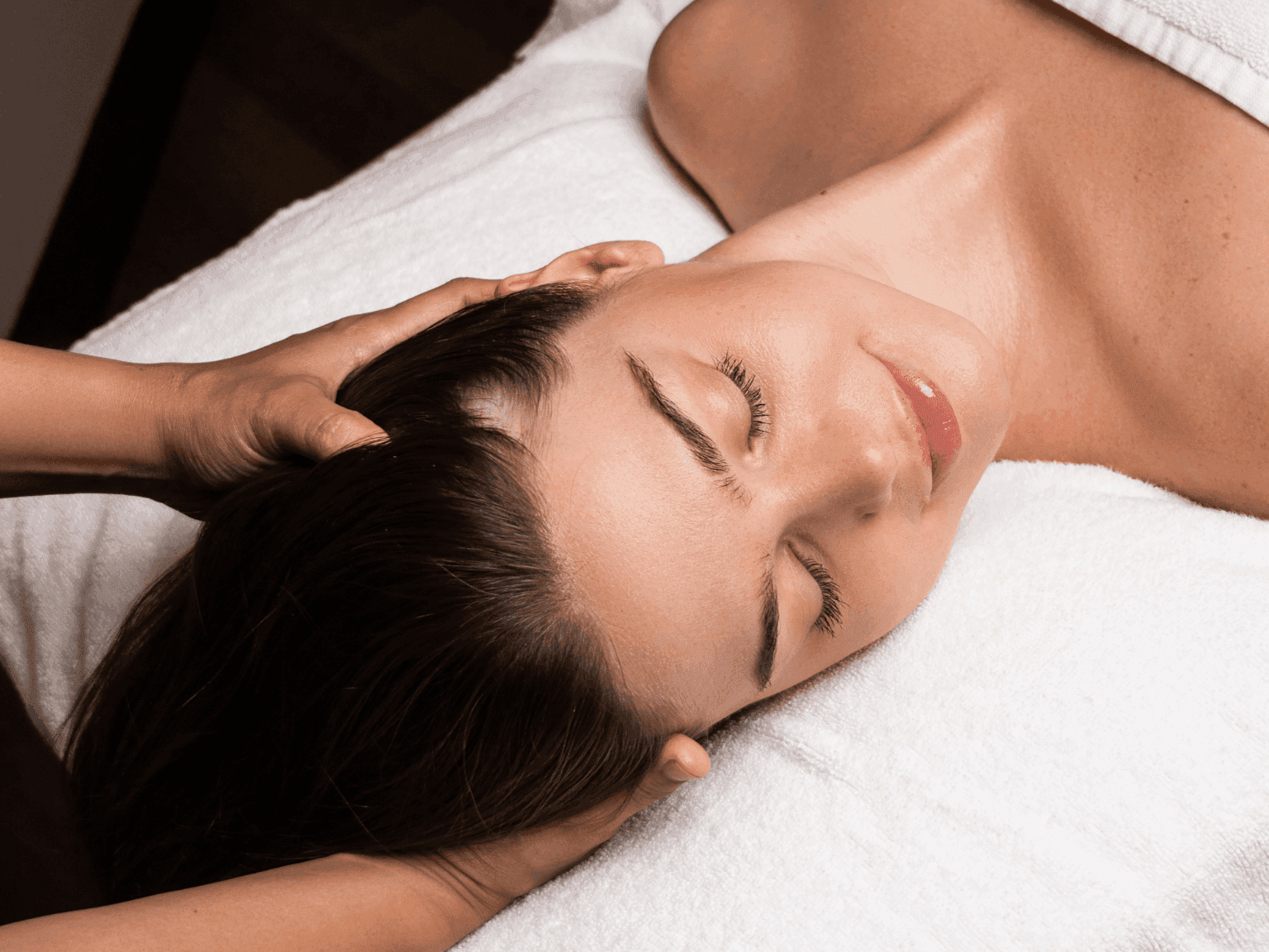 Relaxing head massage treatment with soft lighting, bringing wellness in Dreamworks Spa at DAMAC Maison Distinction