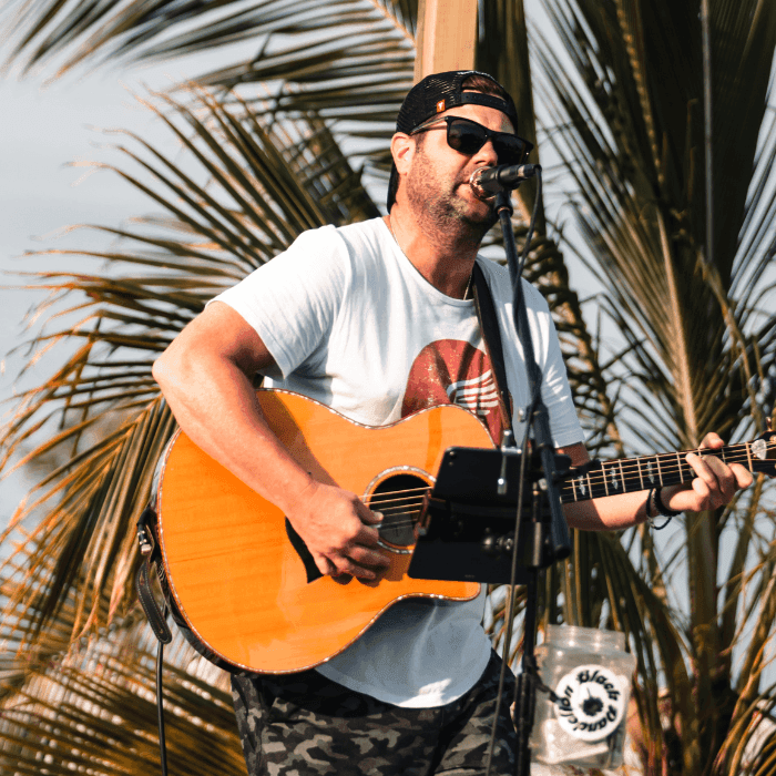 Sean Loosh Man in Sunglasses playing guitar in front of a palm tree at the Star Beach Bar in the Wildwoods
