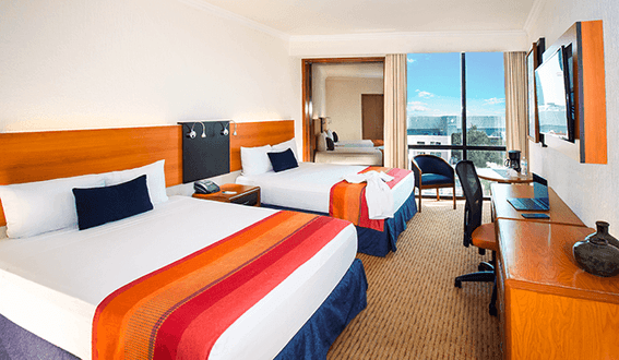 Room interior with beds & furniture at Hotel Guadalajara
