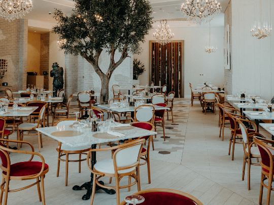 Dining room with a tree and chandeliers in Paparazzi Tuscan Restaurant at Paramount Hotel Midtown