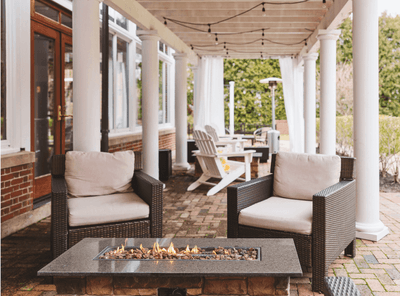 Beautiful stone patio with a lit fire pit and comfortable chairs, an outdoor space at The Exeter Inn