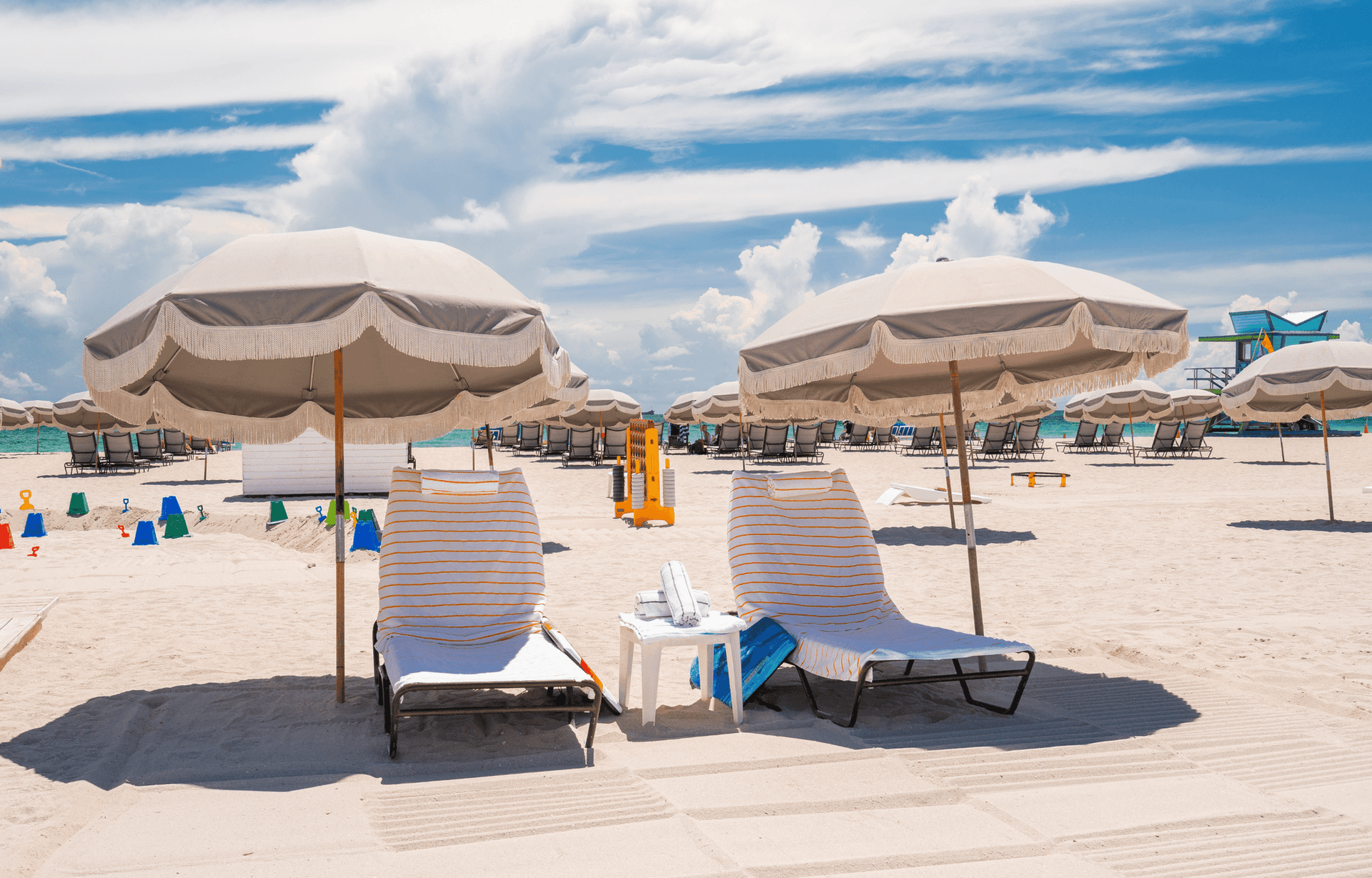 A beach scene with lounge chairs and umbrellas.