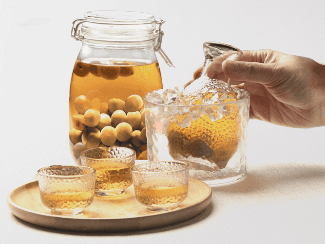 An individual skillfully pouring a drink from a container into a glass, showcasing the act of serving a refreshing beverage.