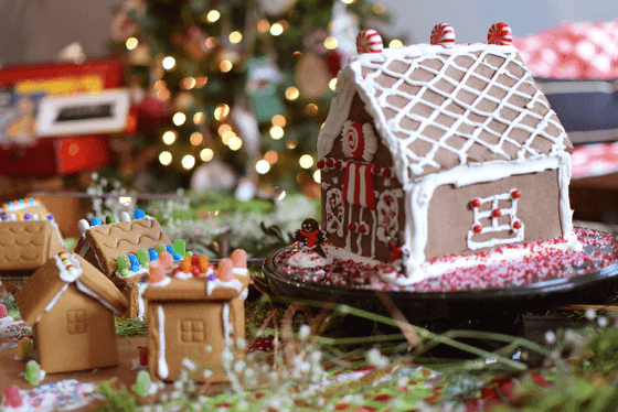 Decorated gingerbread house displayed in front of a Christmas tree at Alderbrook Resort & Spa