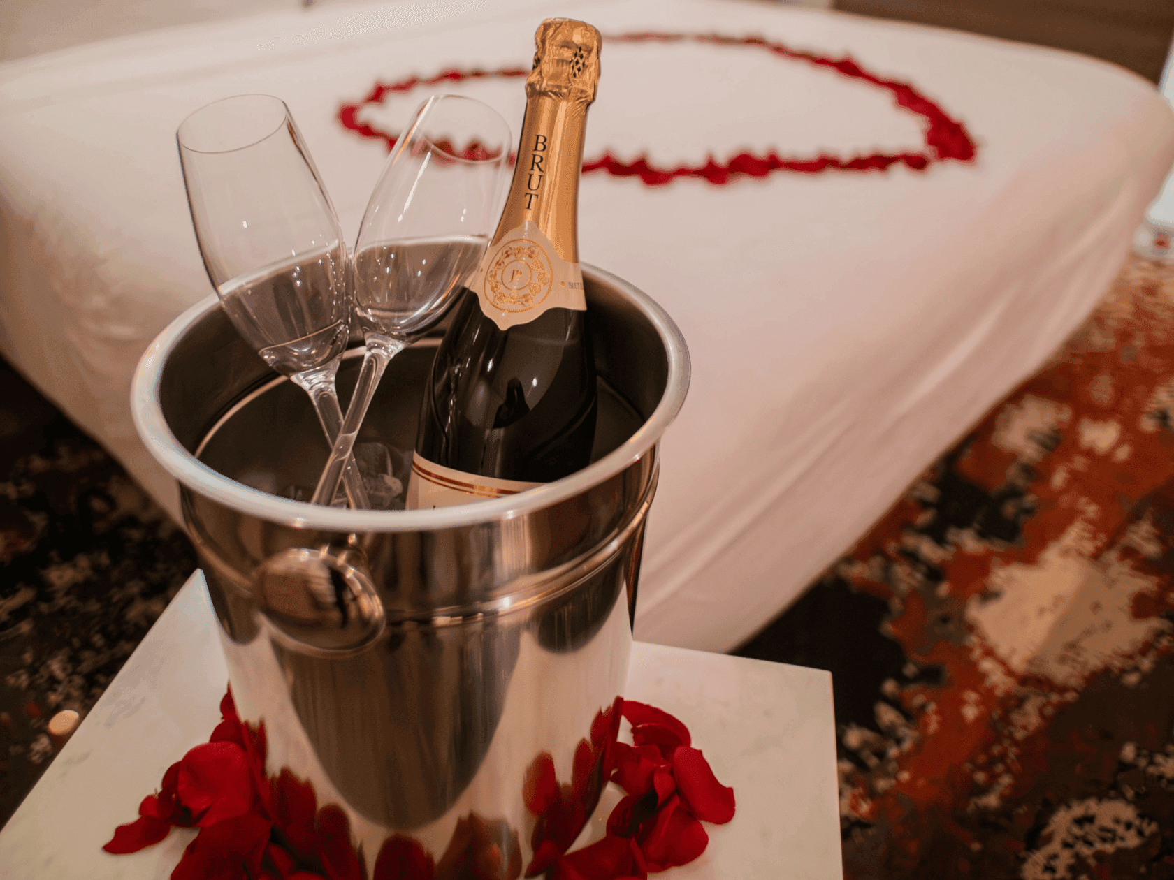 Bottle of champagne in bucket with two glasses and petals at Valentine’s 2026 at Embers.