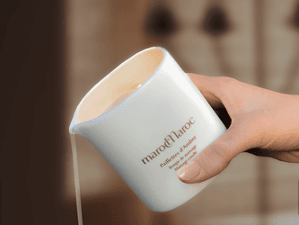Close-up of a hand poring Amber essence at Palazzo Versace