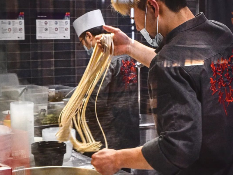 Chef preparing beef noodles in a restaurant at Brady Hotels