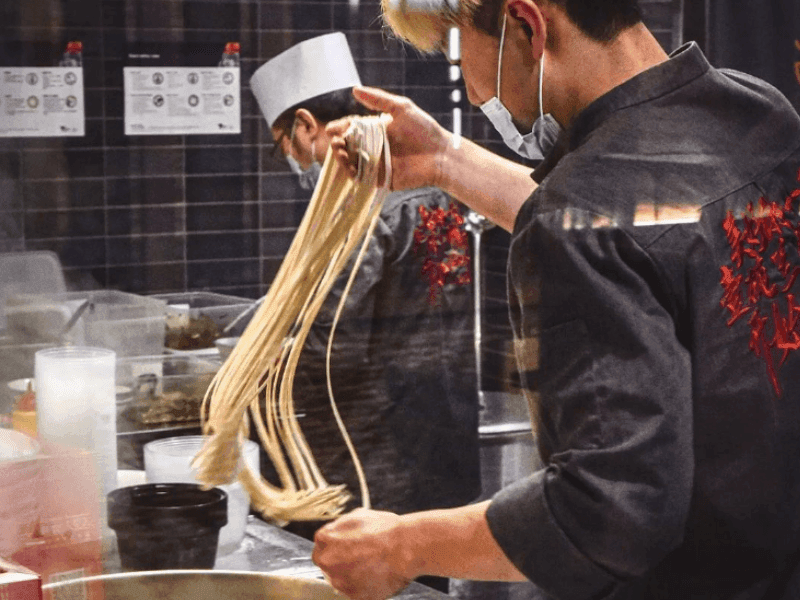 Chef preparing beef noodles in a restaurant at Brady Hotels Central Melbourne