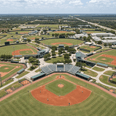 Aerial view of baseball diamonds surrounding a central stadium with grandstands and trees near Star Suites Vero Beach