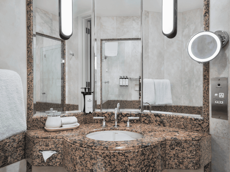 Luxury hotel bathroom with granite vanity, undermount sink, large mirror and premium amenities