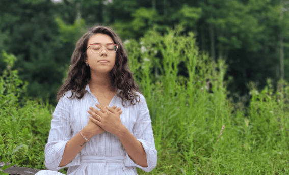 Portrait of a woman meditating outside near Honor’s Haven Retreat