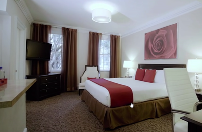 King bed in a room with a large rose painting at Artmore Hotel
