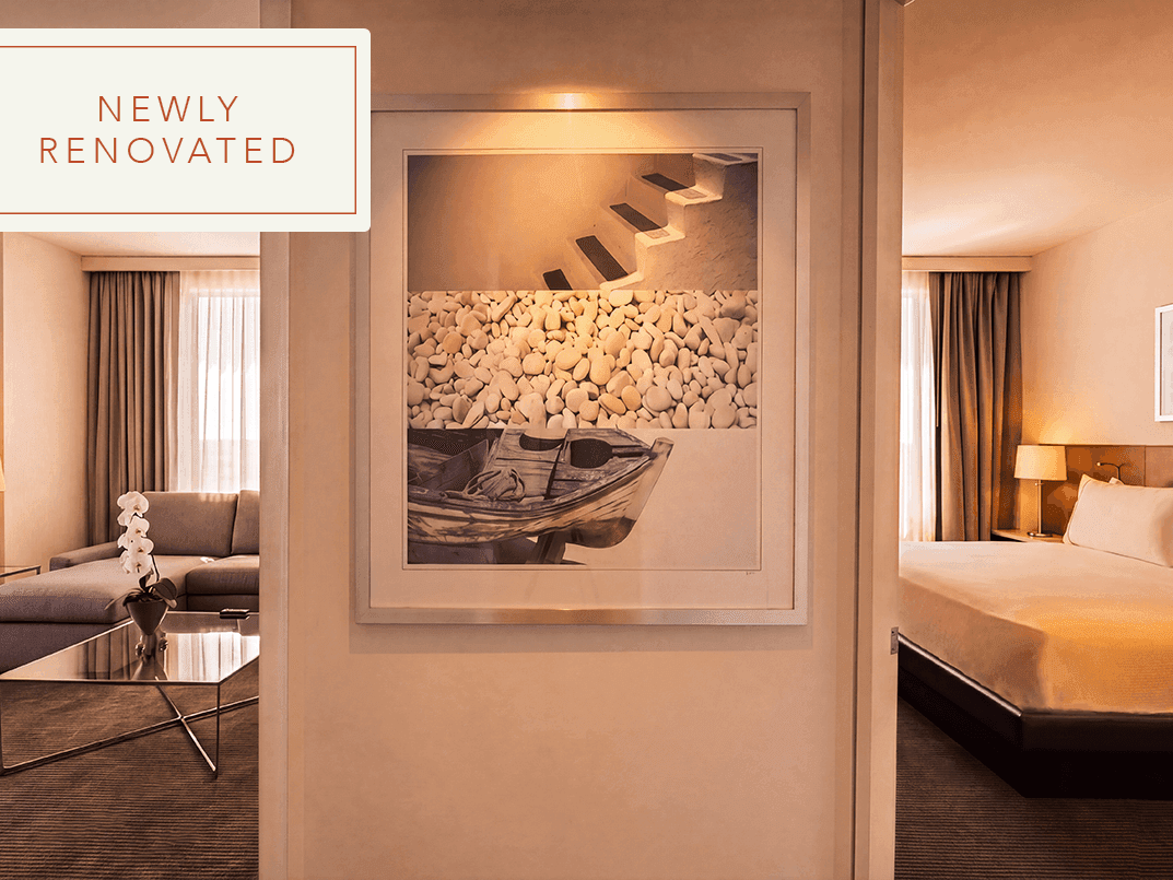 Newly renovated Hotel Arista guest suite featuring modern luxury furnishings, warm lighting, and a spacious king bedroom