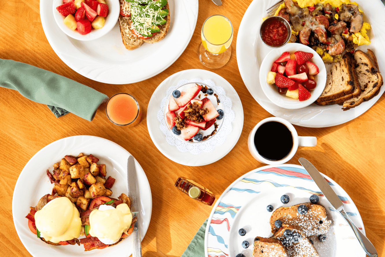 a breakfast table with various dishes and drinks
