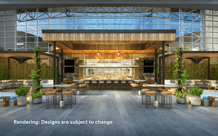 Atrium with a bar, seating areas, and greenery under a glass ceiling at Diplomat Beach Resort