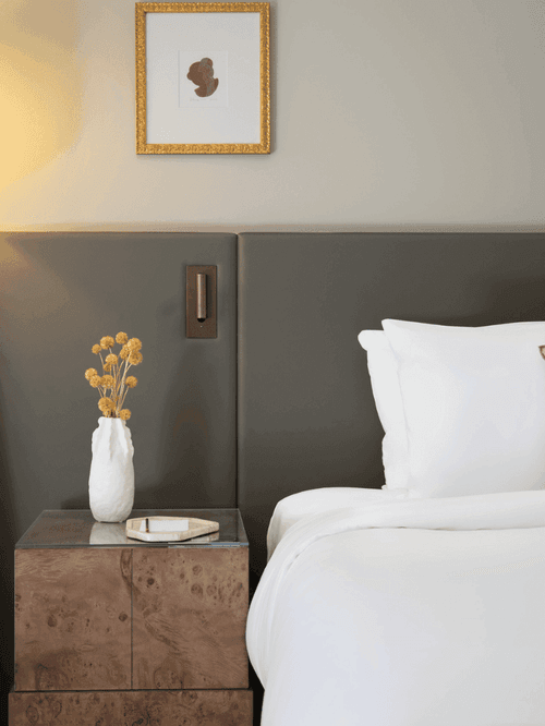 Luxury hotel bedroom with twin beds, floor lamp, and modern minimalist decor