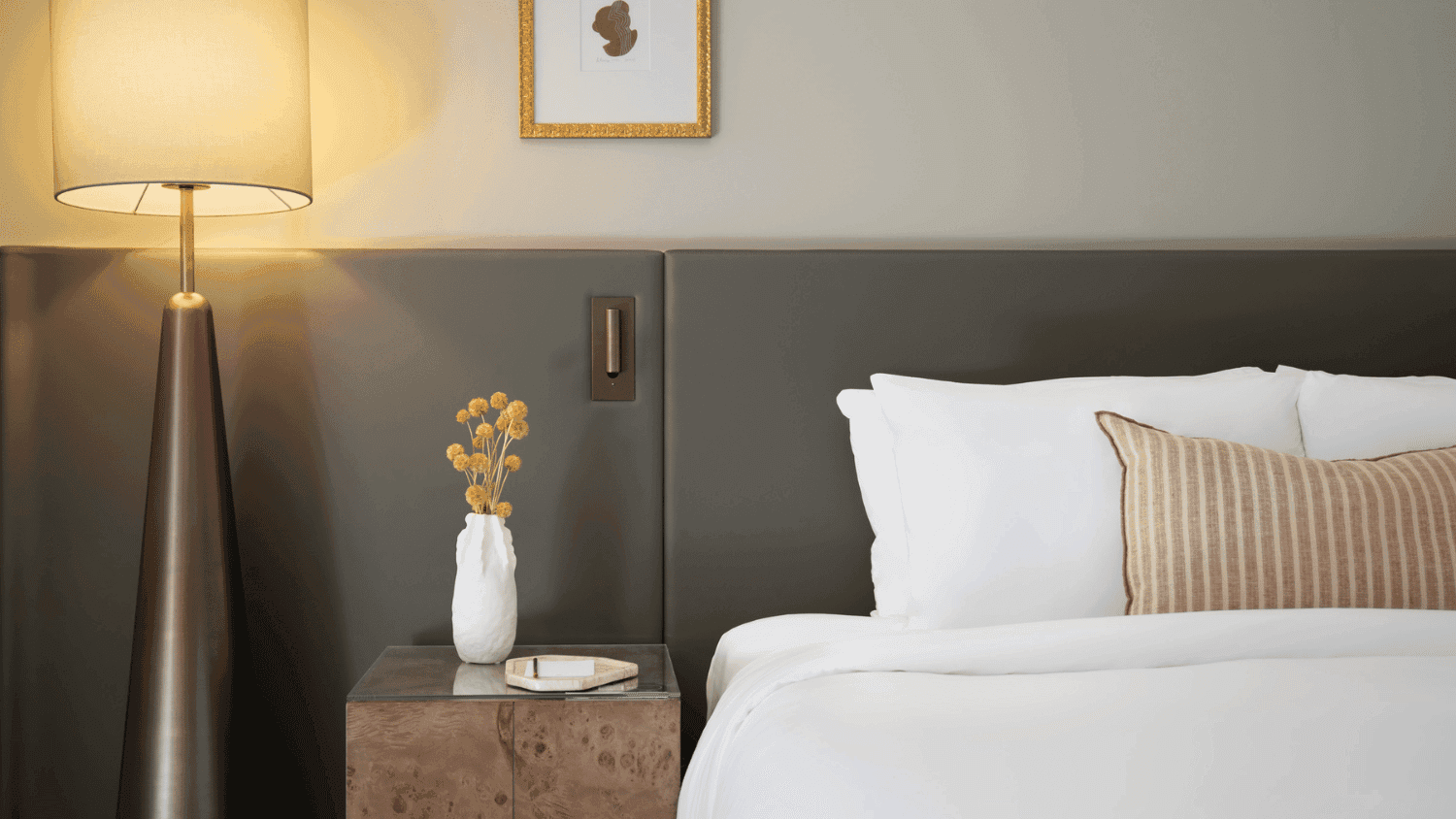 Luxury hotel bedroom with twin beds, floor lamp, and modern minimalist decor