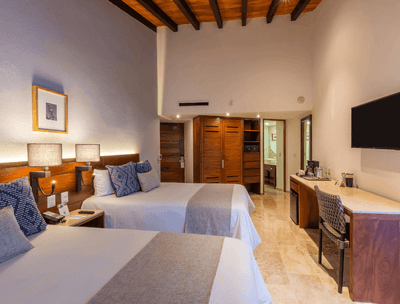 Deluxe Two Double Beds with mirror, closet, work desk and TV at Buenaventura Grand Hotel and Spa