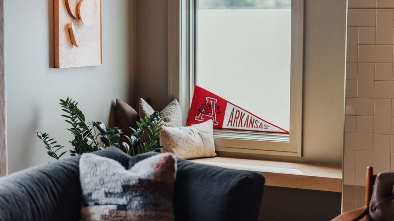 Clean and organized guest room with a flag in support of Arkansas State