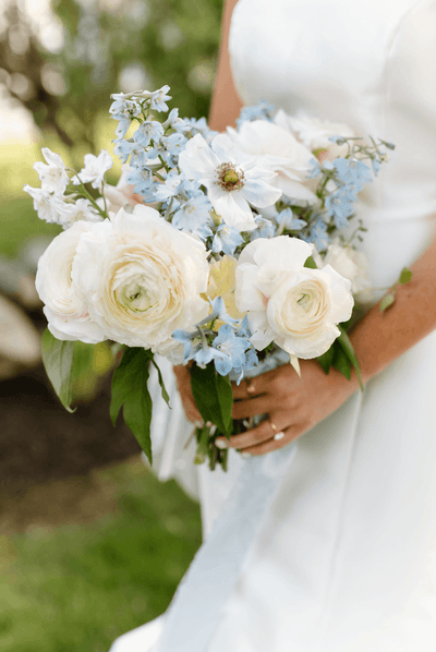 Bride holding a white and blue floral wedding bouquet at Anchorage By The Sea