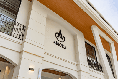Low angle exterior view of the hotel sing on the entrance facade at Amora Hotel