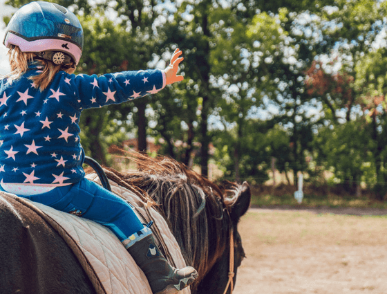 Closeup of a kid riding a horse at Richmond Hill Hotel