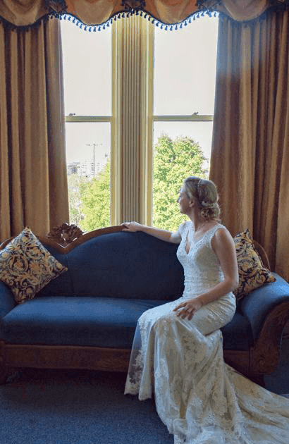 Bride overlooking the view from a window lounge at Huntingdon Manor