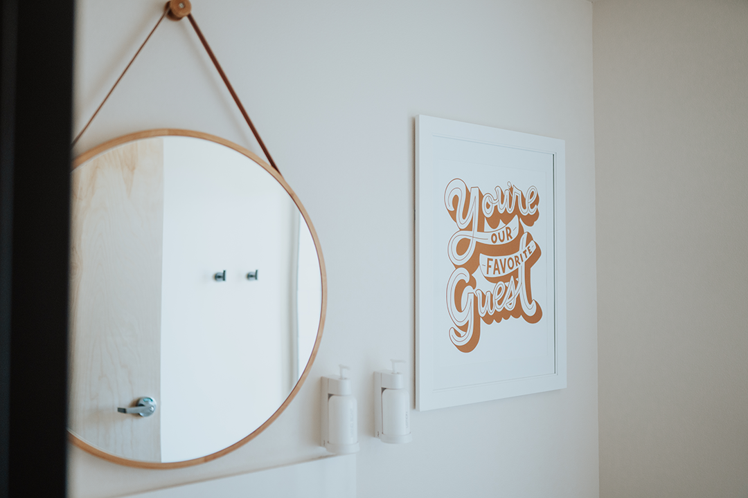 A Mirror & a frame hung on a room wall at Kinship Landing