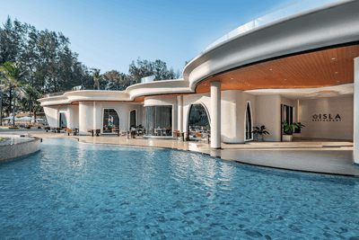 Exterior view of the hotel and outdoor pool area on a sunny day at Amora Hotel