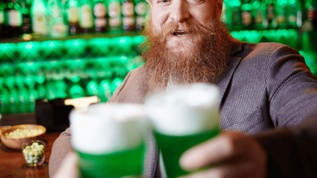 Festive friends toasting with green beers in celebration of St. Patrick’s Day