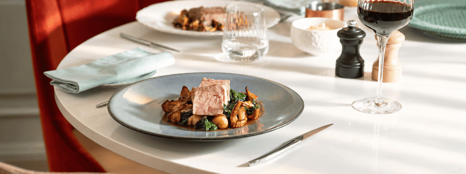 Gourmet plated dishes with red wine on white tablecloth at Le Céladon, Hôtel Westminster - Paris